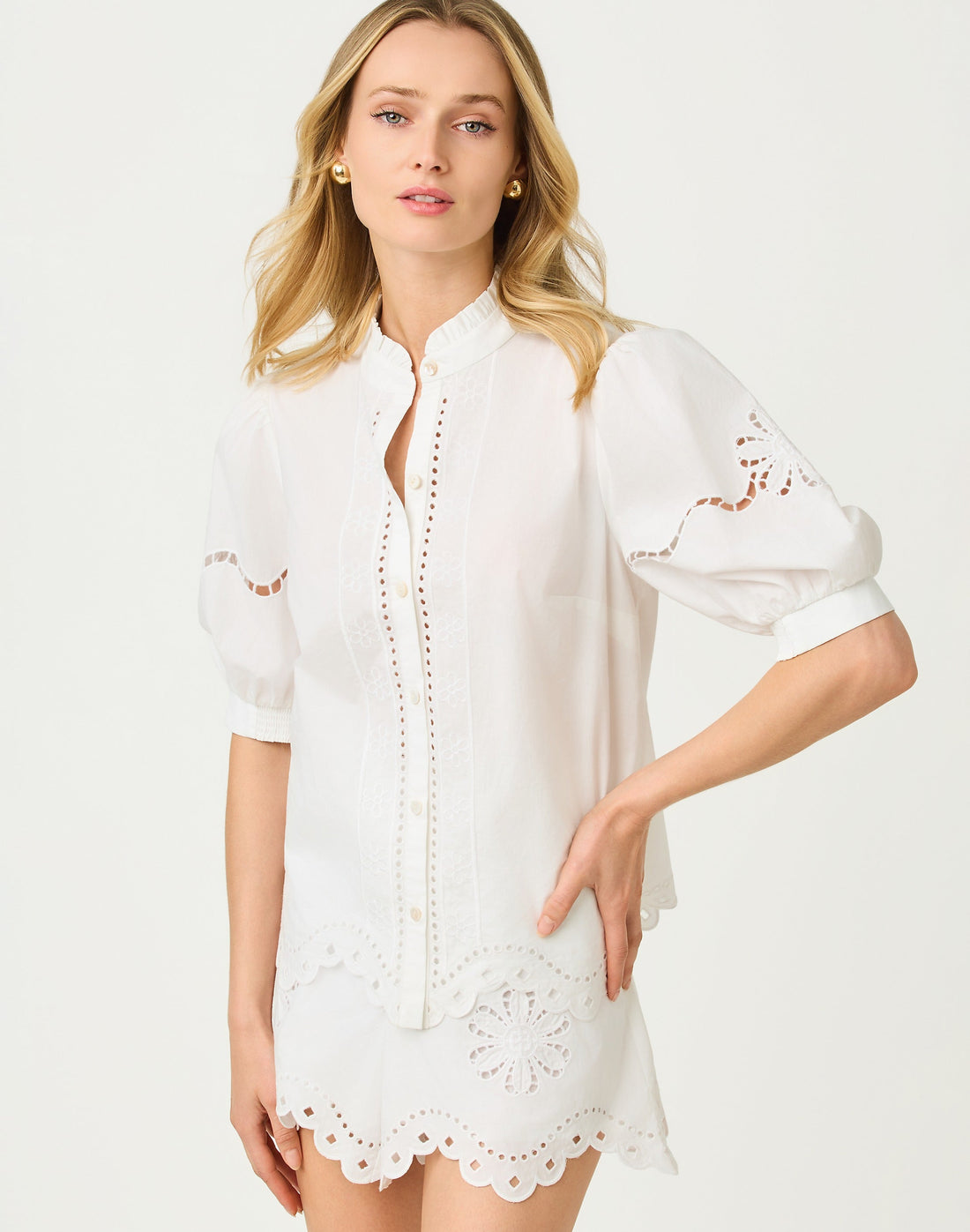 Woman wearing a white dress with lace details on a light gray background