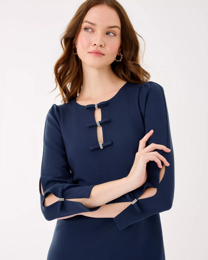 Woman wearing a navy blue dress with cut-out sleeves on a white background