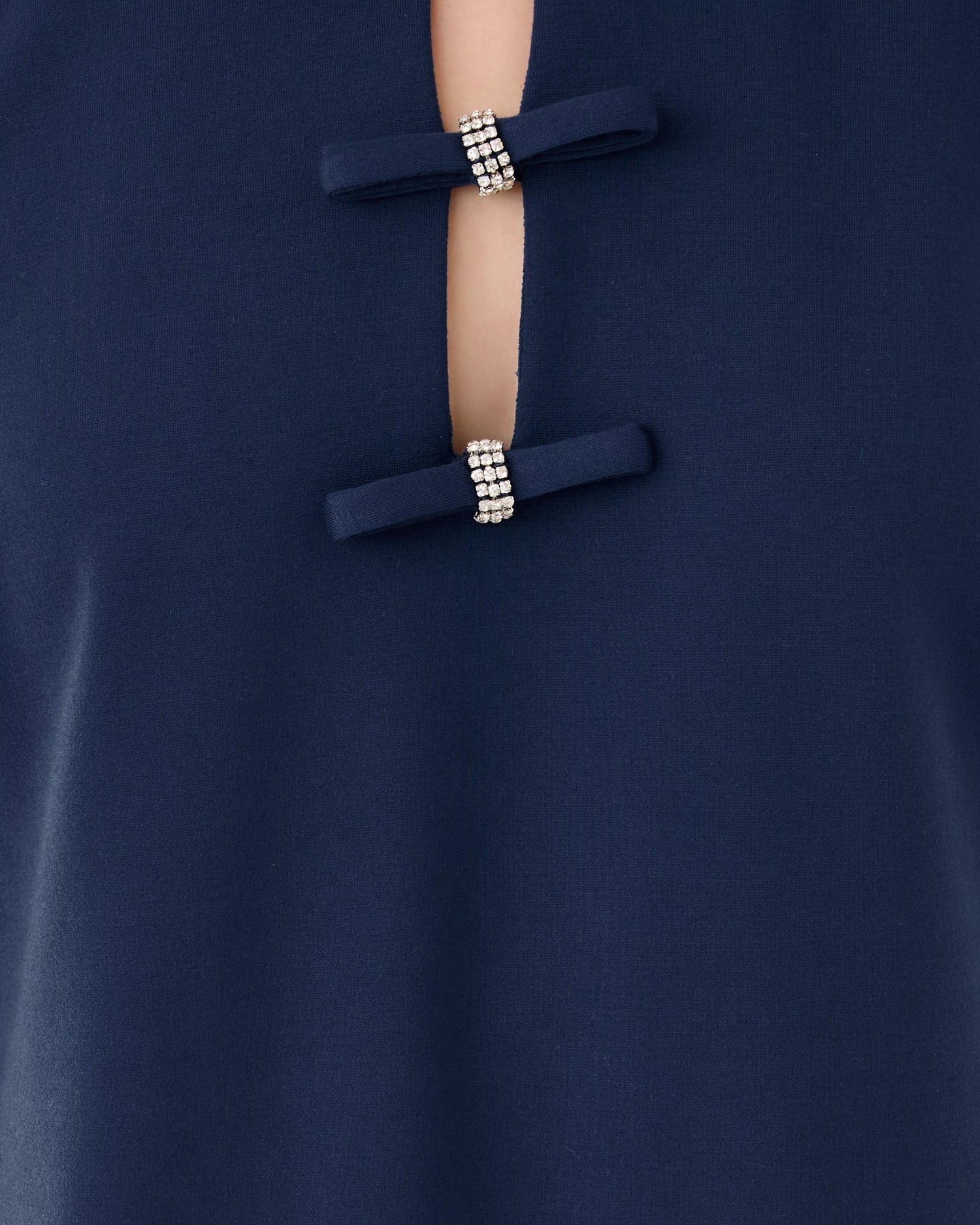 Close-up of a navy blue garment with decorative buttons featuring beads.