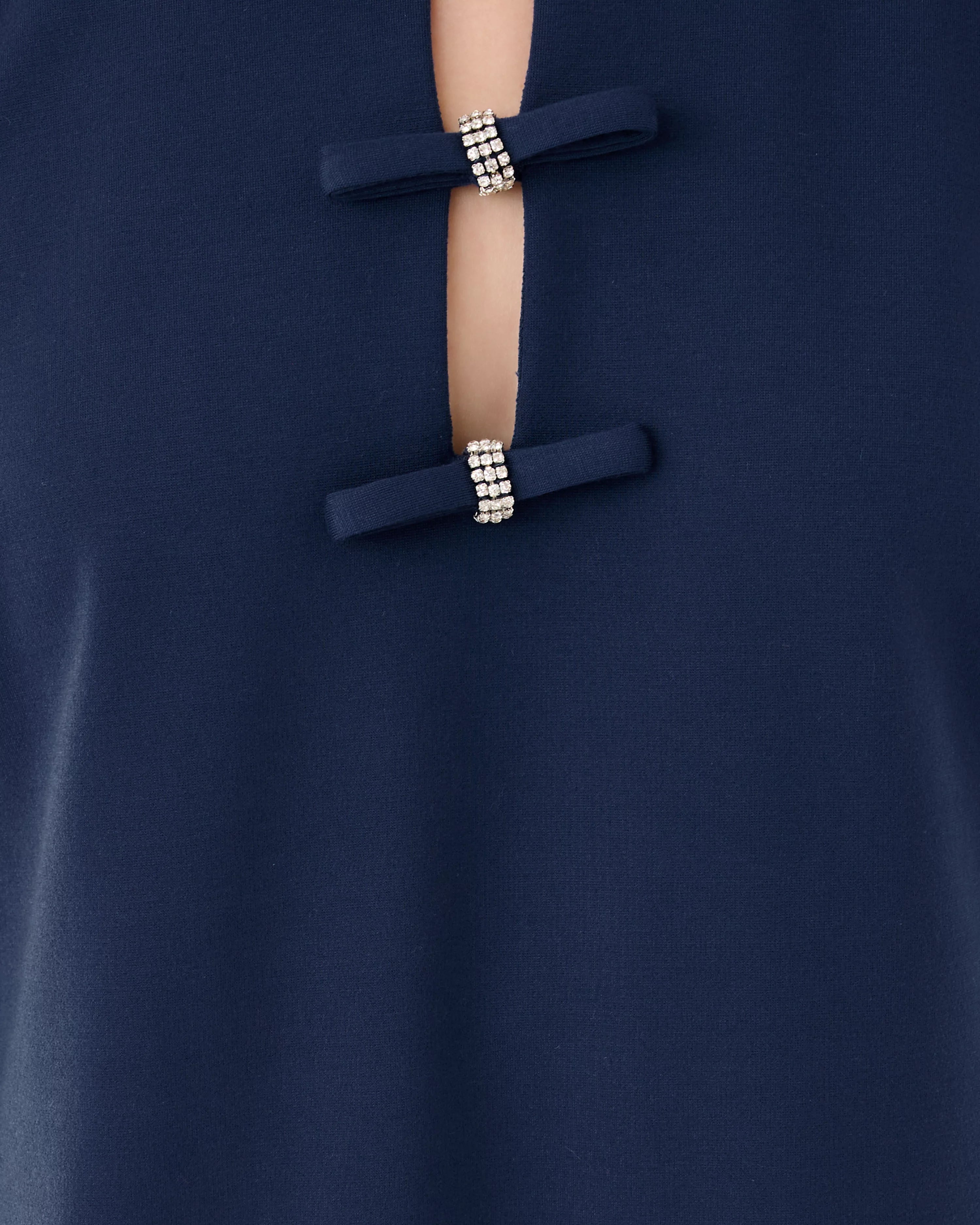 Close-up of a navy blue garment with decorative buttons featuring beads.