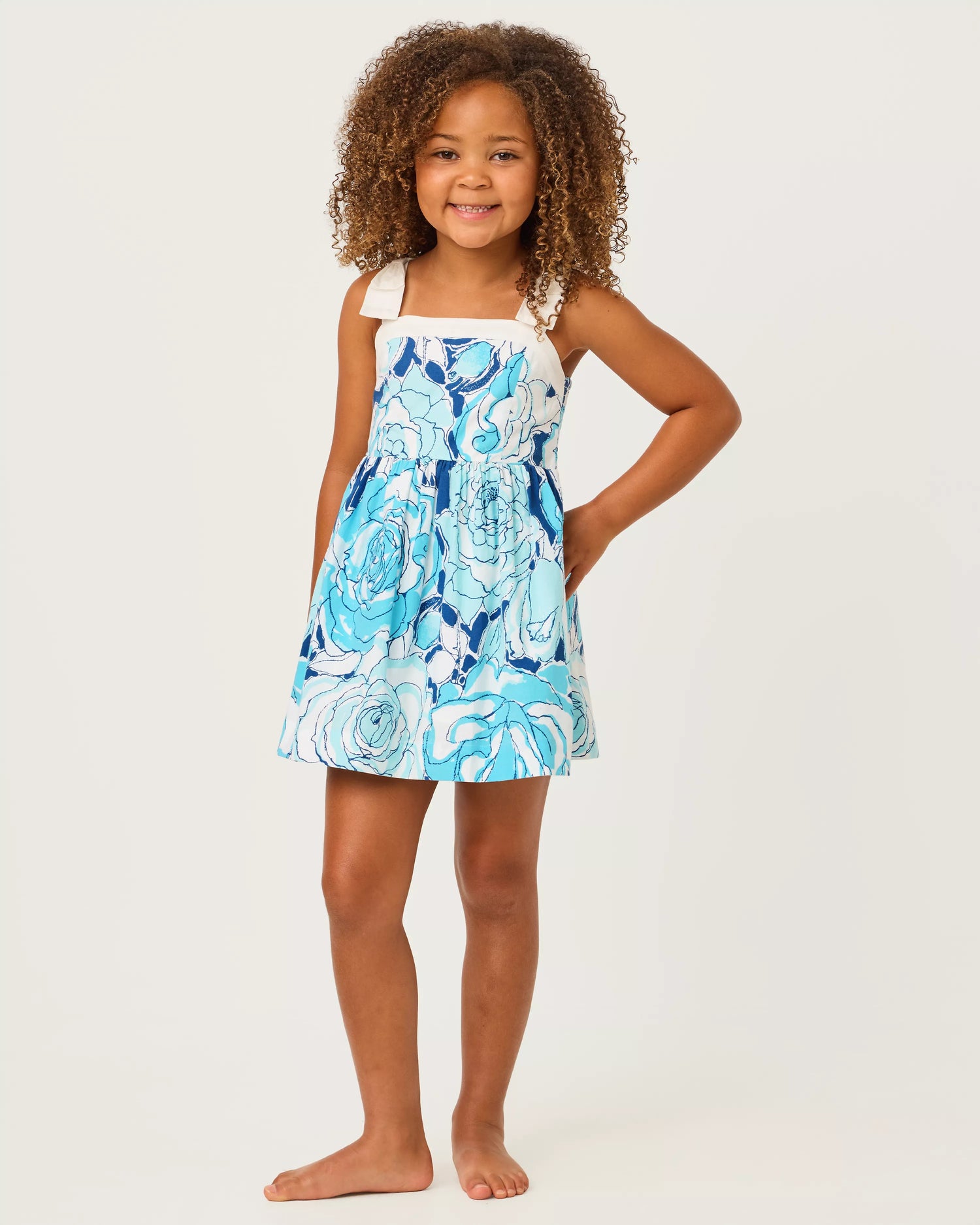 Young girl wearing a blue floral dress on a white background
