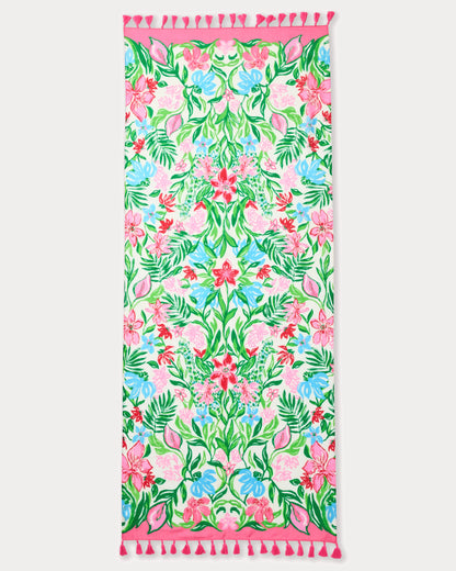 Floral patterned towel with pink border and tassels on a white background