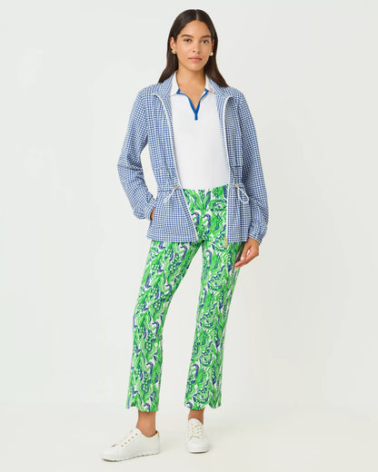 Woman wearing a blue checkered jacket, white shirt, and green patterned pants on a white background