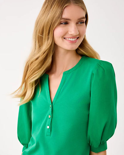 Woman wearing a green blouse with a plain background