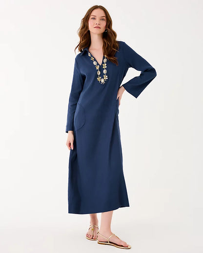 Woman wearing a blue dress with floral embroidery on a white background