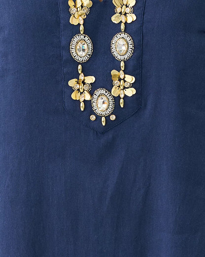Gold necklace with floral and circular designs on a blue background