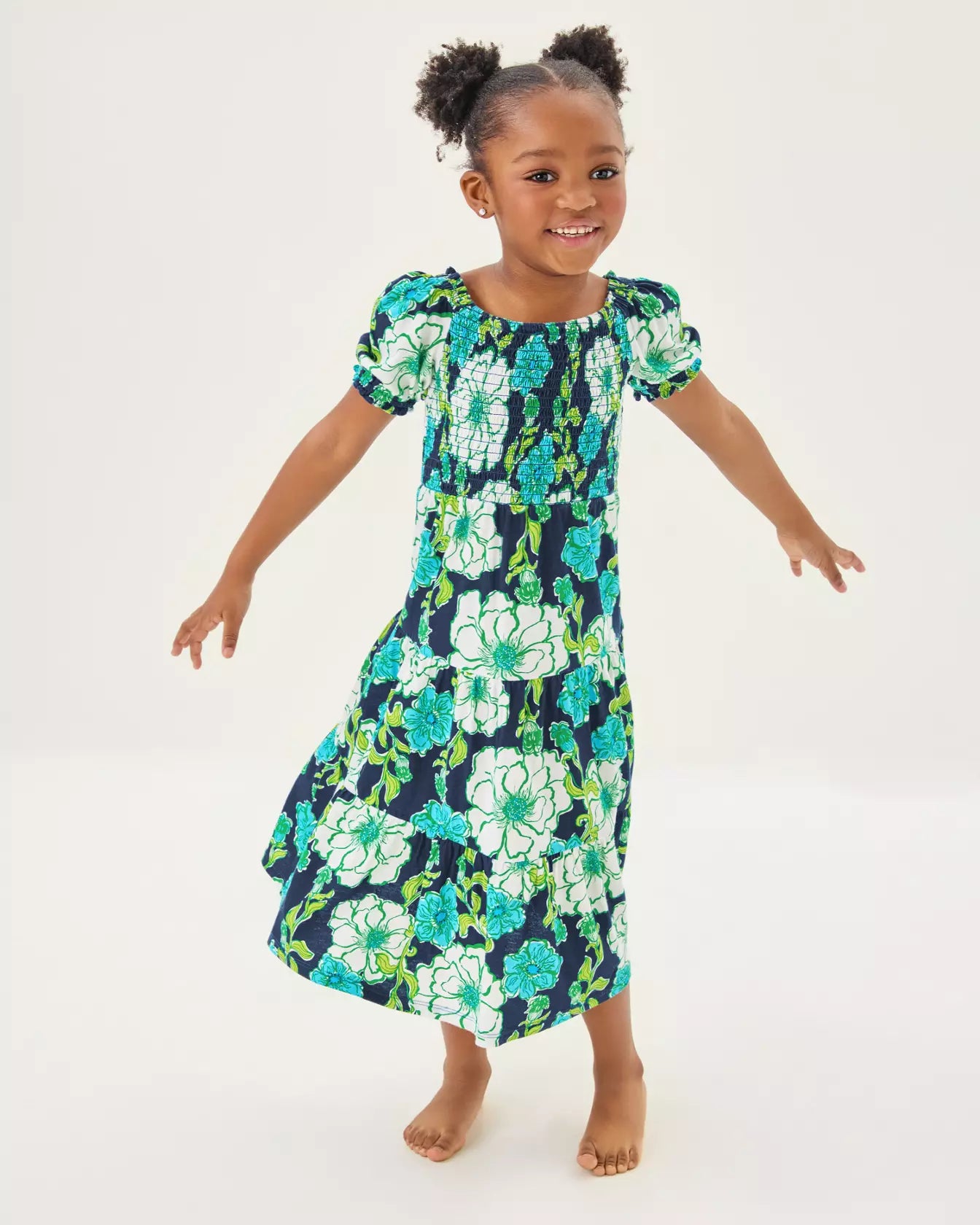 Young girl wearing a floral dress on a white background