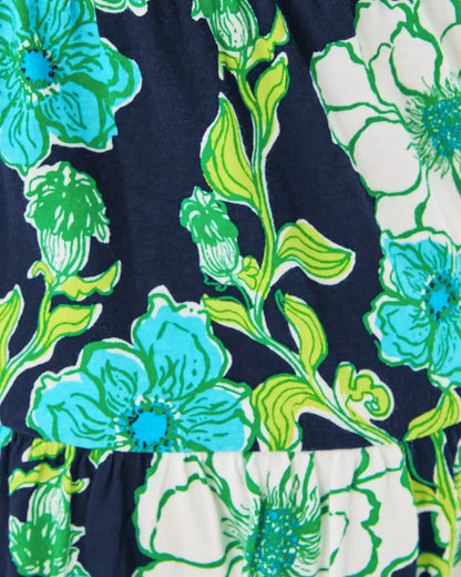 Close-up of a floral pattern with blue, green, and white flowers on a dark background.