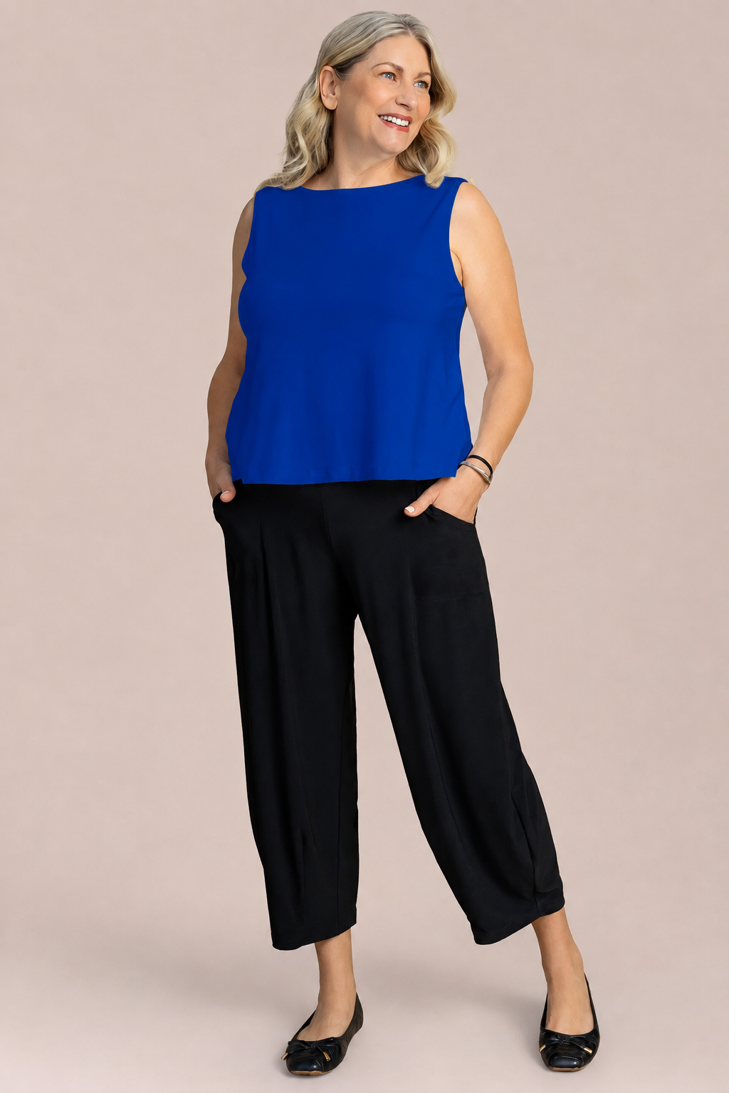 A woman modeling a sleeveless royal blue top Nu Flared Shell by Sympli in Lapis Blue