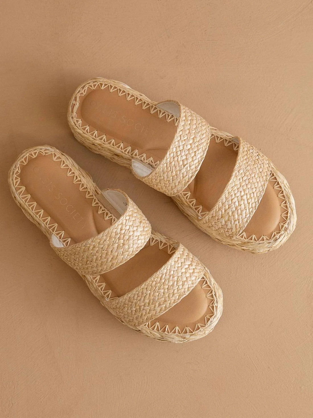 Pair of woven sandals on a beige background