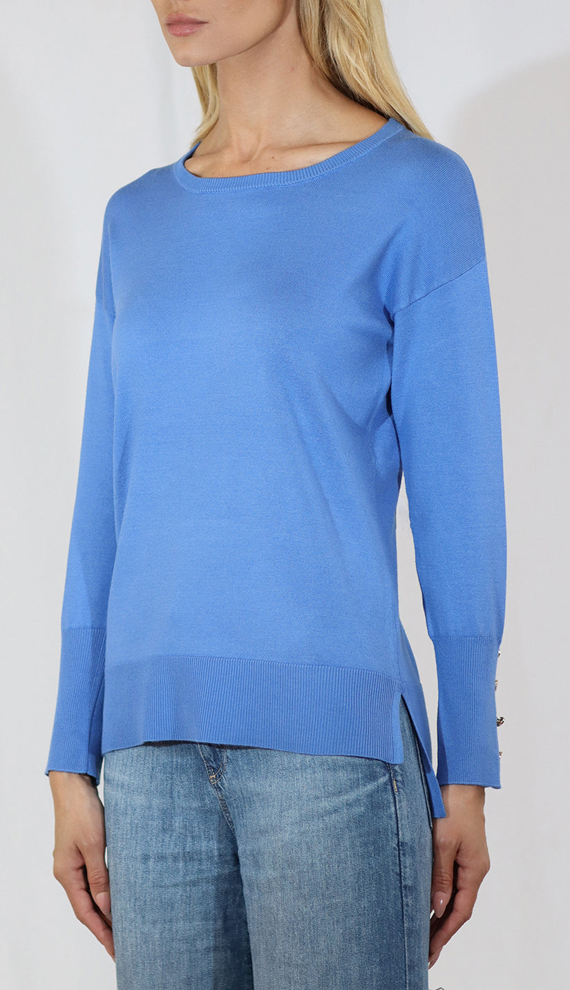 Woman wearing a blue long-sleeve top with a white background