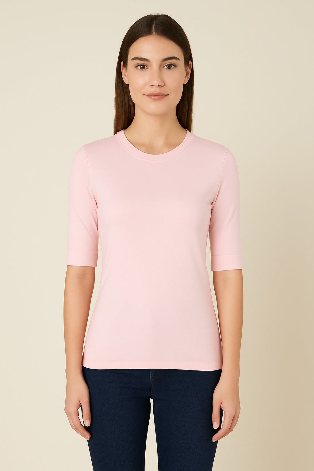 Woman wearing a light pink sweater against a beige background