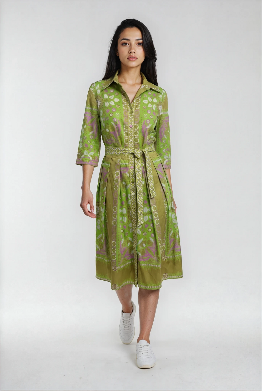 Woman wearing a green patterned dress on a white background