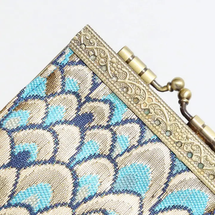Close-up of a decorative clutch bag with floral pattern and gold clasp.