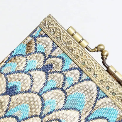 Close-up of a decorative clutch bag with floral pattern and gold clasp.