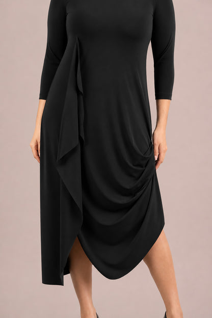 A woman modeling a black three-quarter sleeve midi dress with draped side detail and a high-low hem Sympli Drama Dress 3/4 Sleeves in Black