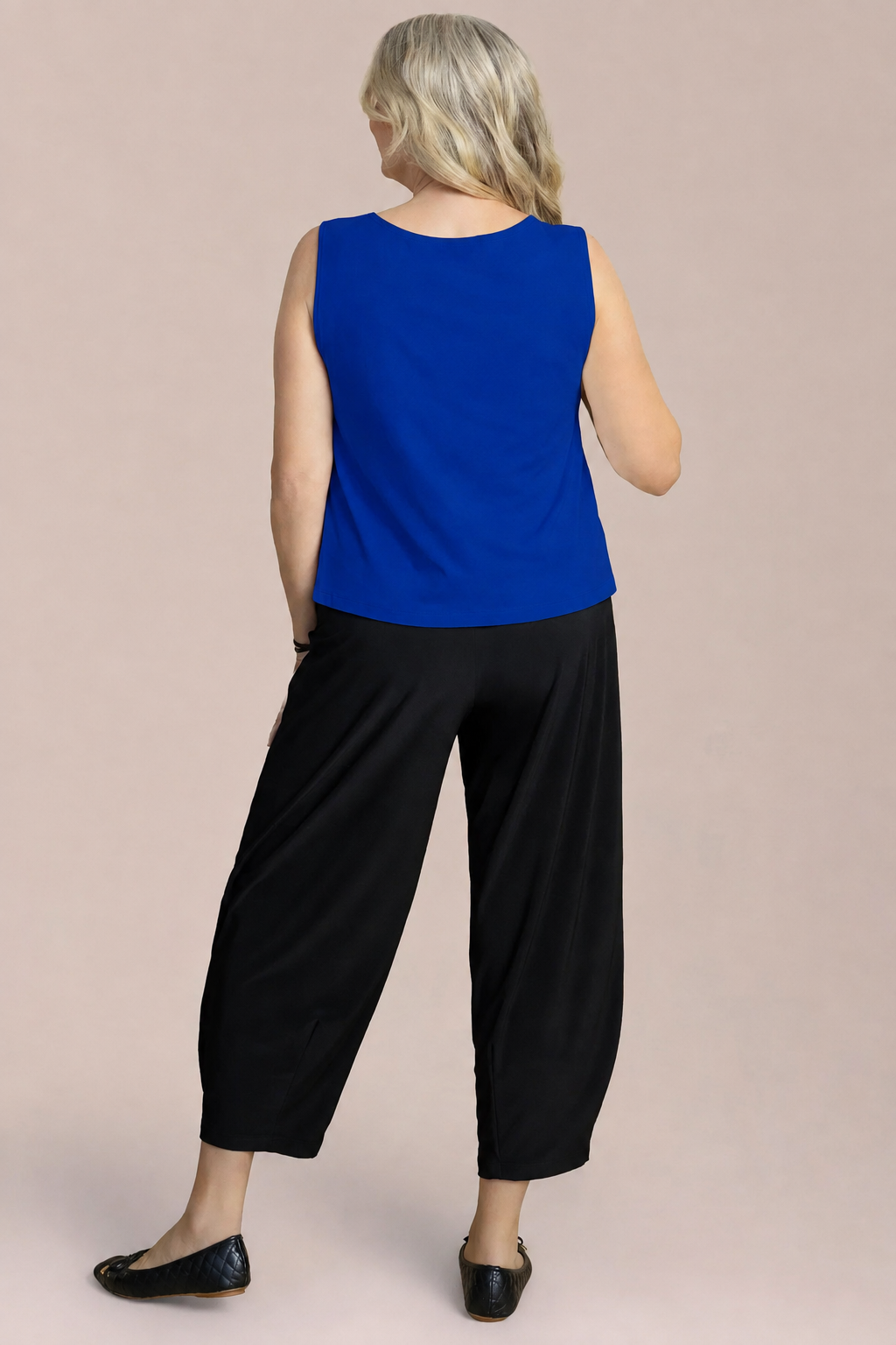 A woman modeling a sleeveless royal blue top Nu Flared Shell by Sympli in Lapis Blue