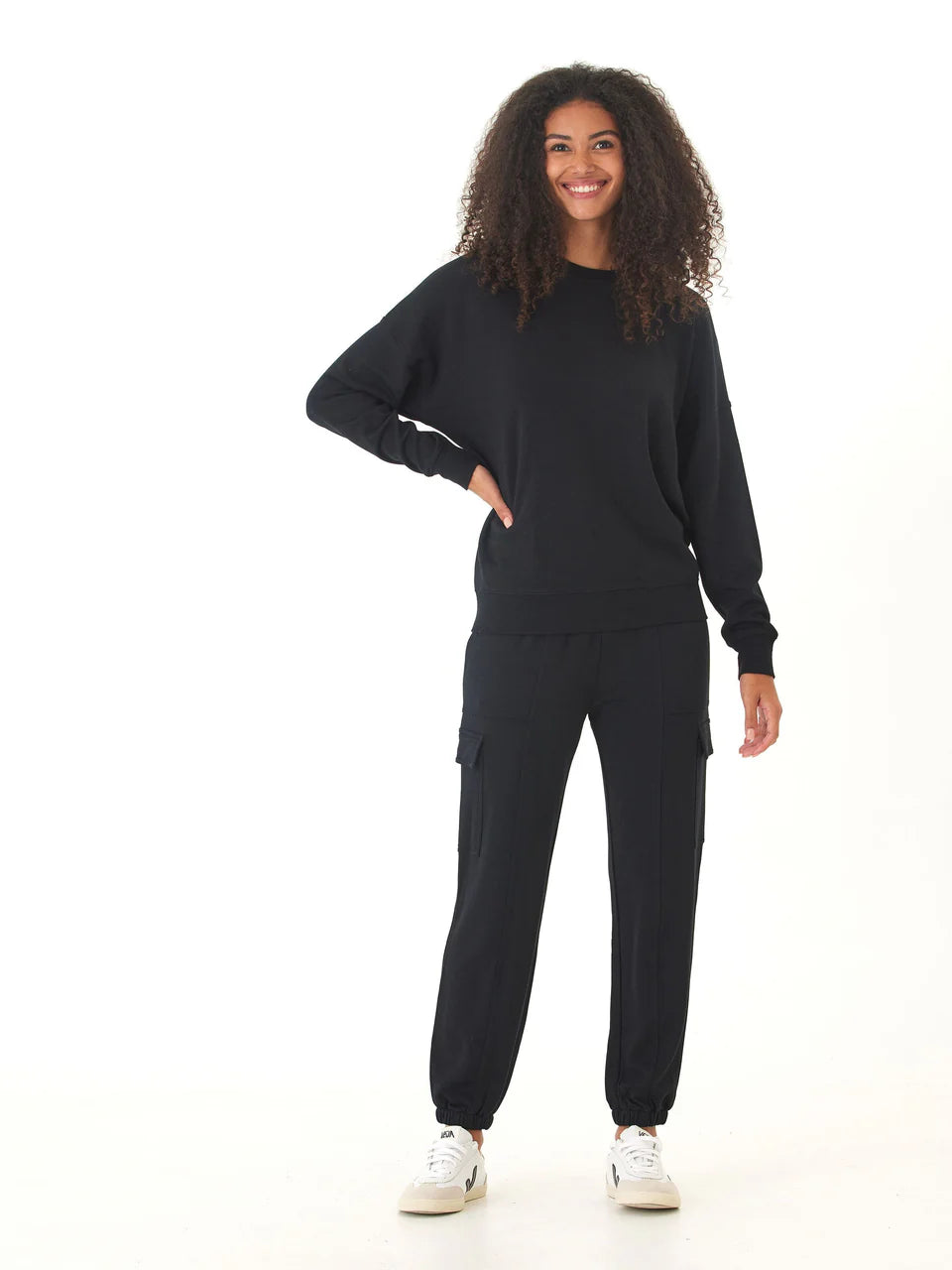 Person wearing a black tracksuit on a white background