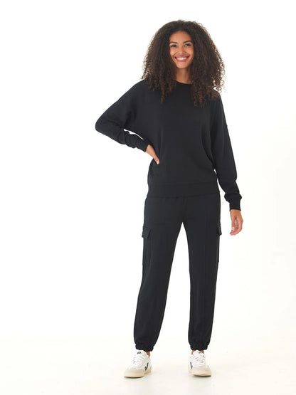 Person wearing a black tracksuit on a white background