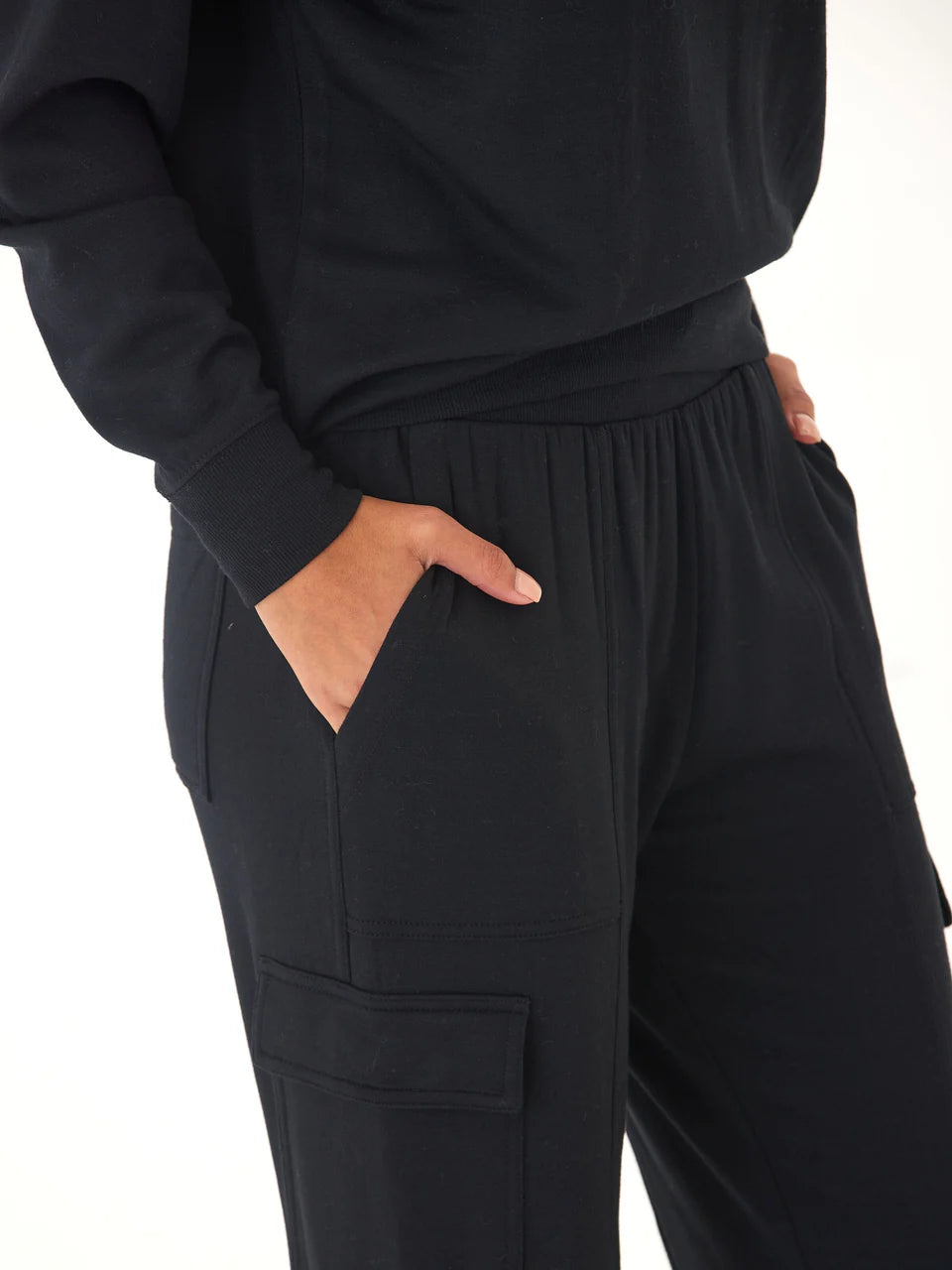 Person wearing black pants with a white background