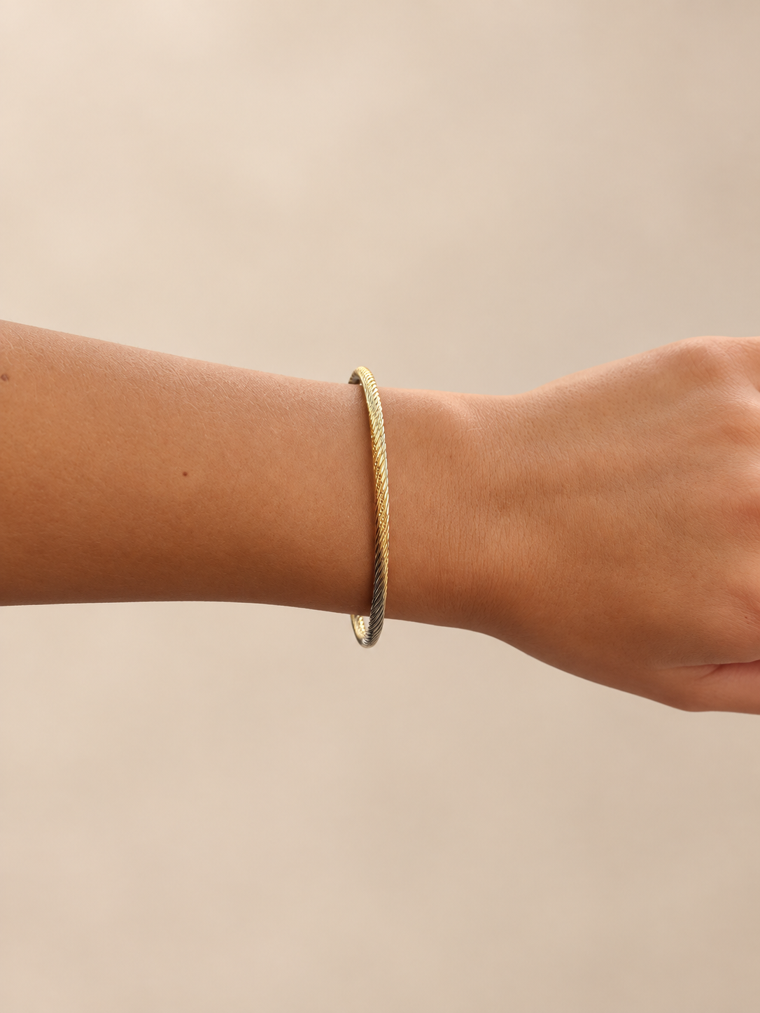 cable cuff bracelet featuring a textured gold-tone design finished with polished silver-tone tips