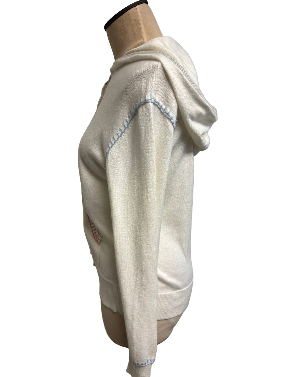 White zip up wit pink, blue, and gray detailing on a mannequin against a plain wall