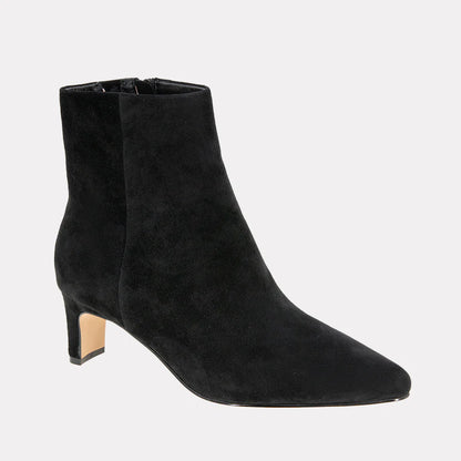 Black suede ankle boots on a light gray background