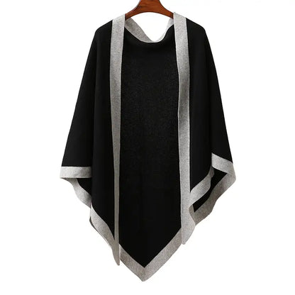 Black poncho with gray trim on a wooden hanger against a white background