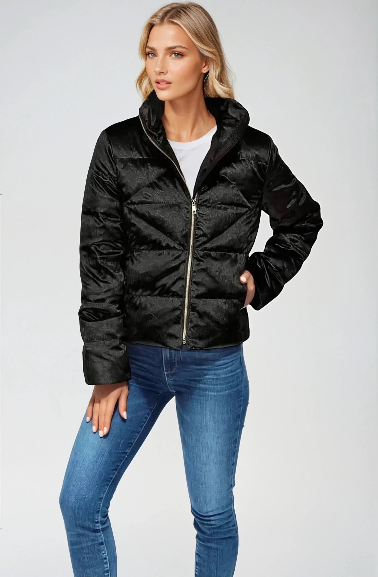 Woman wearing a black puffer jacket and blue jeans on a white background