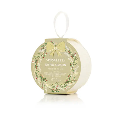 Spongelle festive bath body buffer in apricot amber packaging with decorative elements on a white background