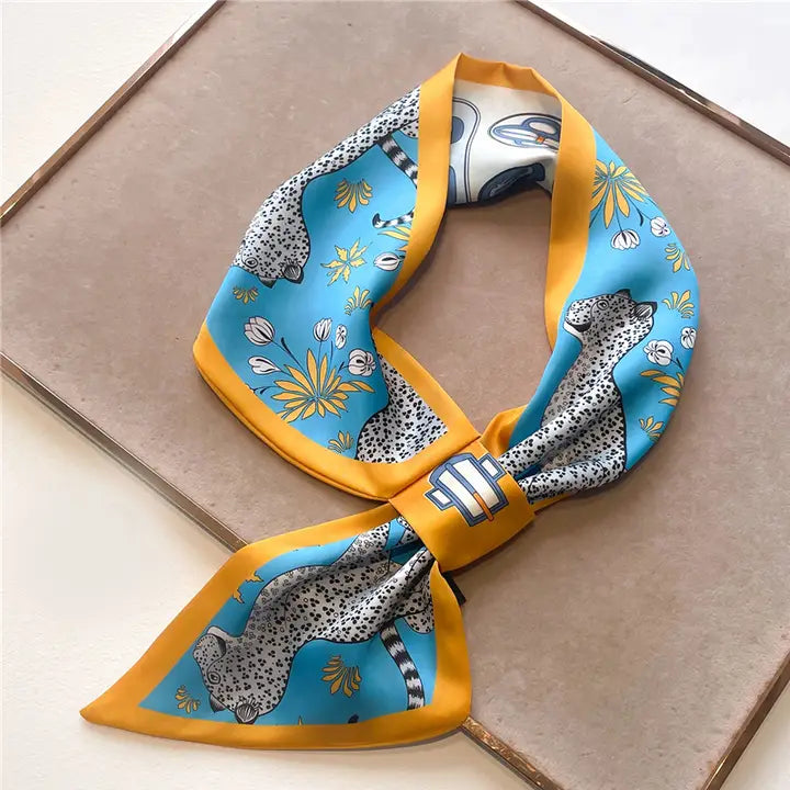 Decorative scarf with animal print and yellow border on a textured surface