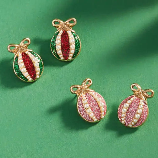 Decorative Christmas ornament earrings charms on a green background