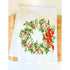 White towel with a decorative wreath design featuring oysters, greenery, and a red bow on a wooden surface.