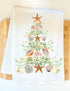 White towel with a decorative Christmas tree design featuring shells and starfish on a wooden surface.