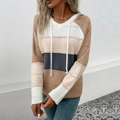 Woman wearing a striped sweater with a neutral background