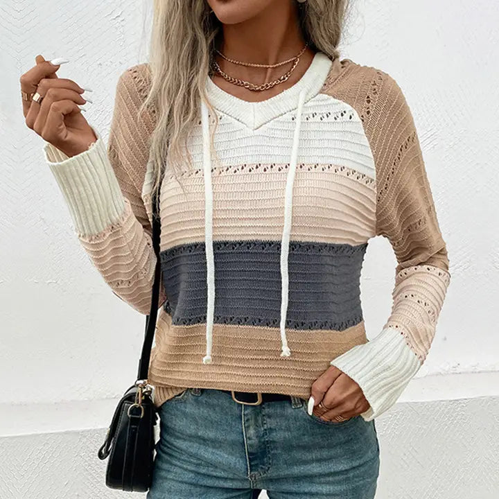 Person wearing a striped sweater with a hood against a white background