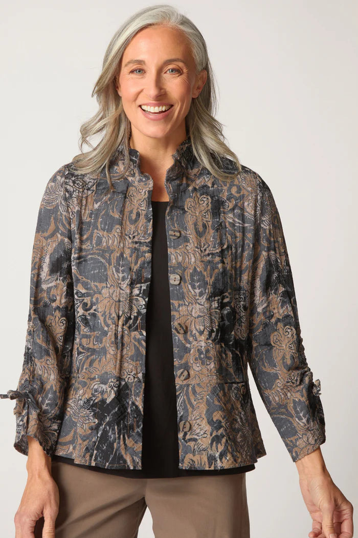Woman wearing a patterned jacket against a plain background