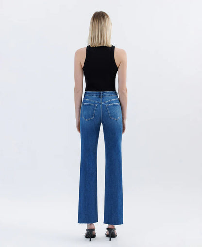 Person wearing blue jeans and a black top on a white background