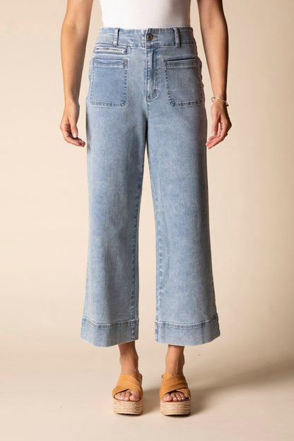 Light blue jeans worn by a person on a beige background