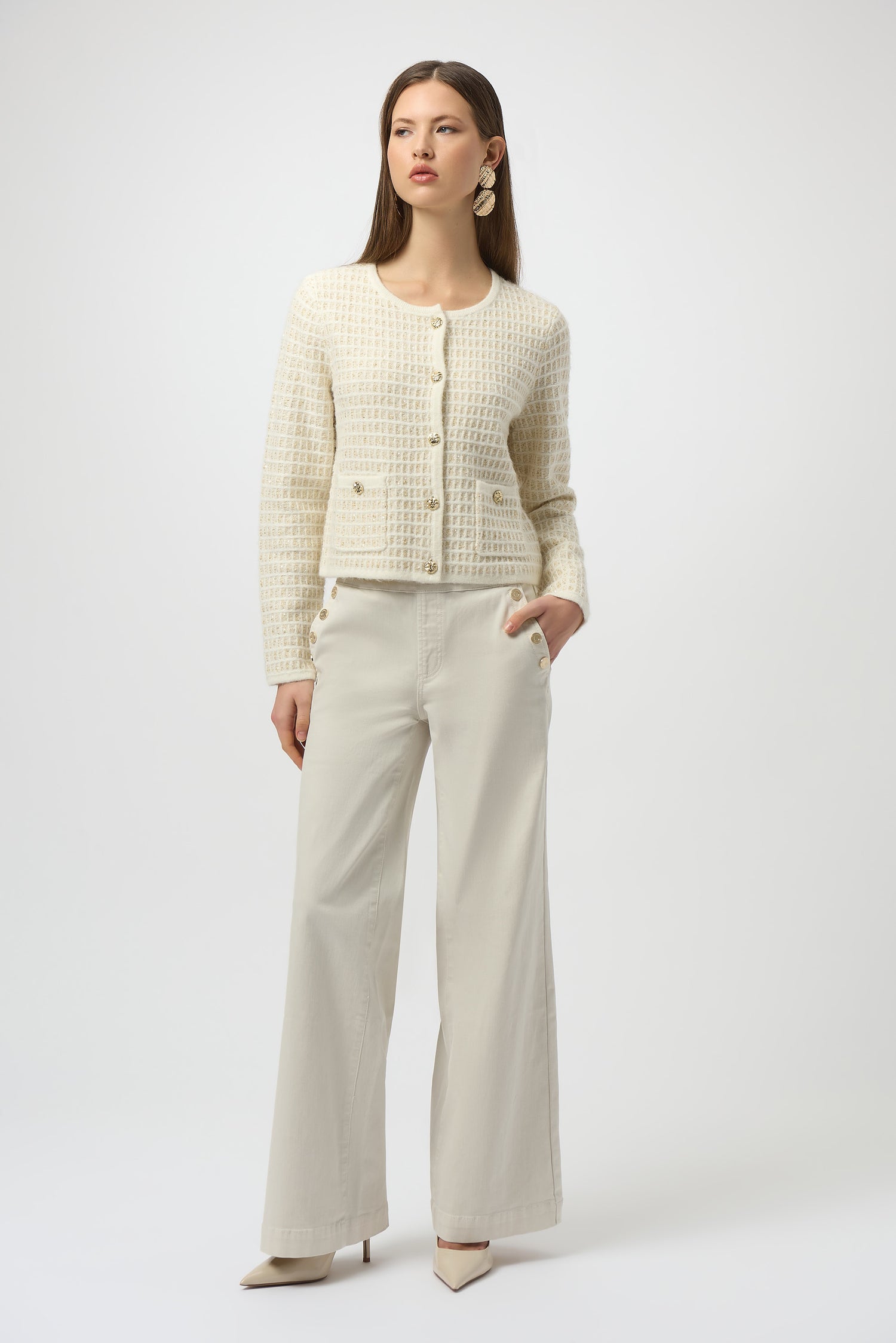 Woman wearing a cream-colored textured jacket and pants on a white background