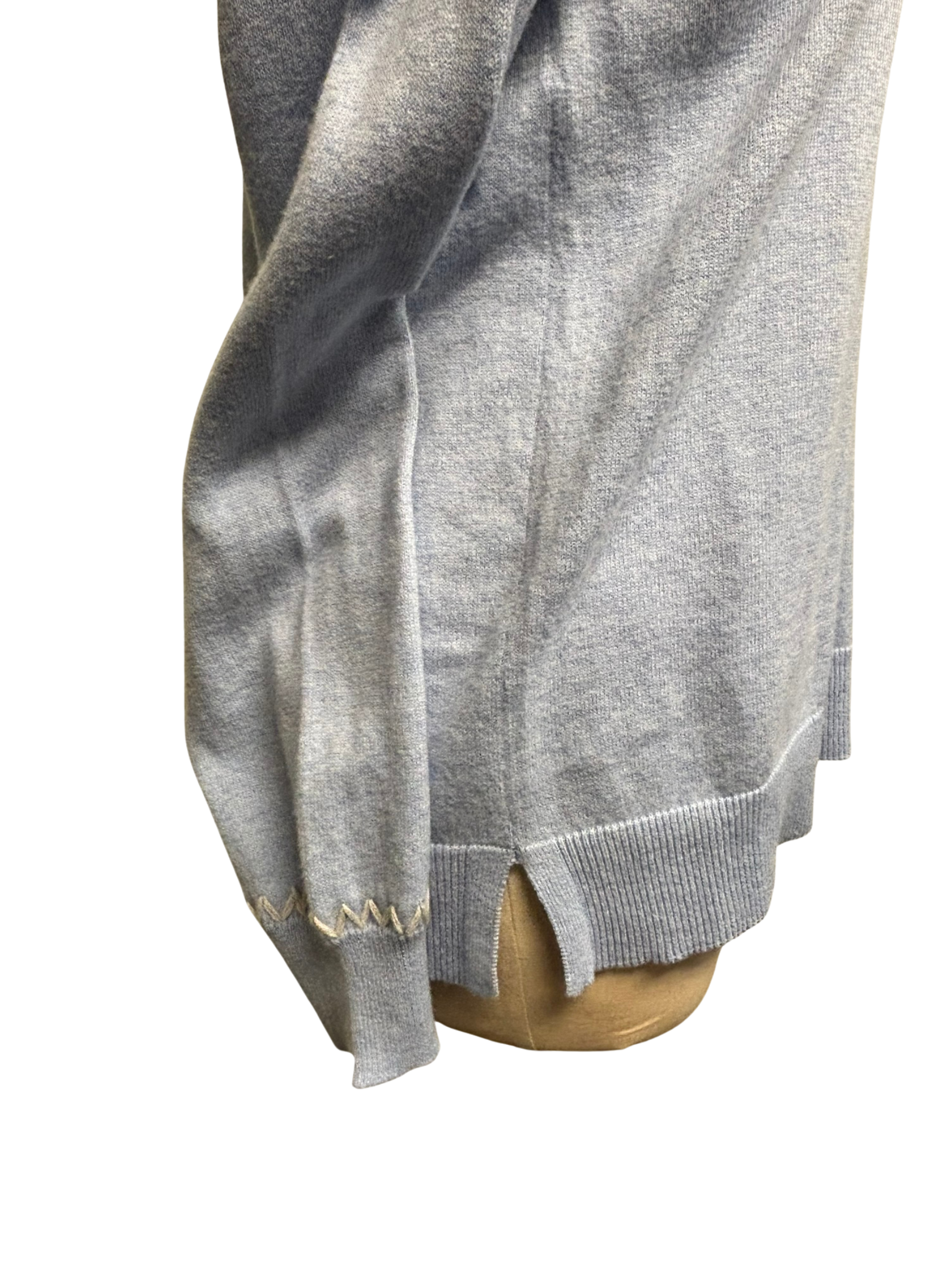 Light blue sweater with white stiching on a mannequin with a white background