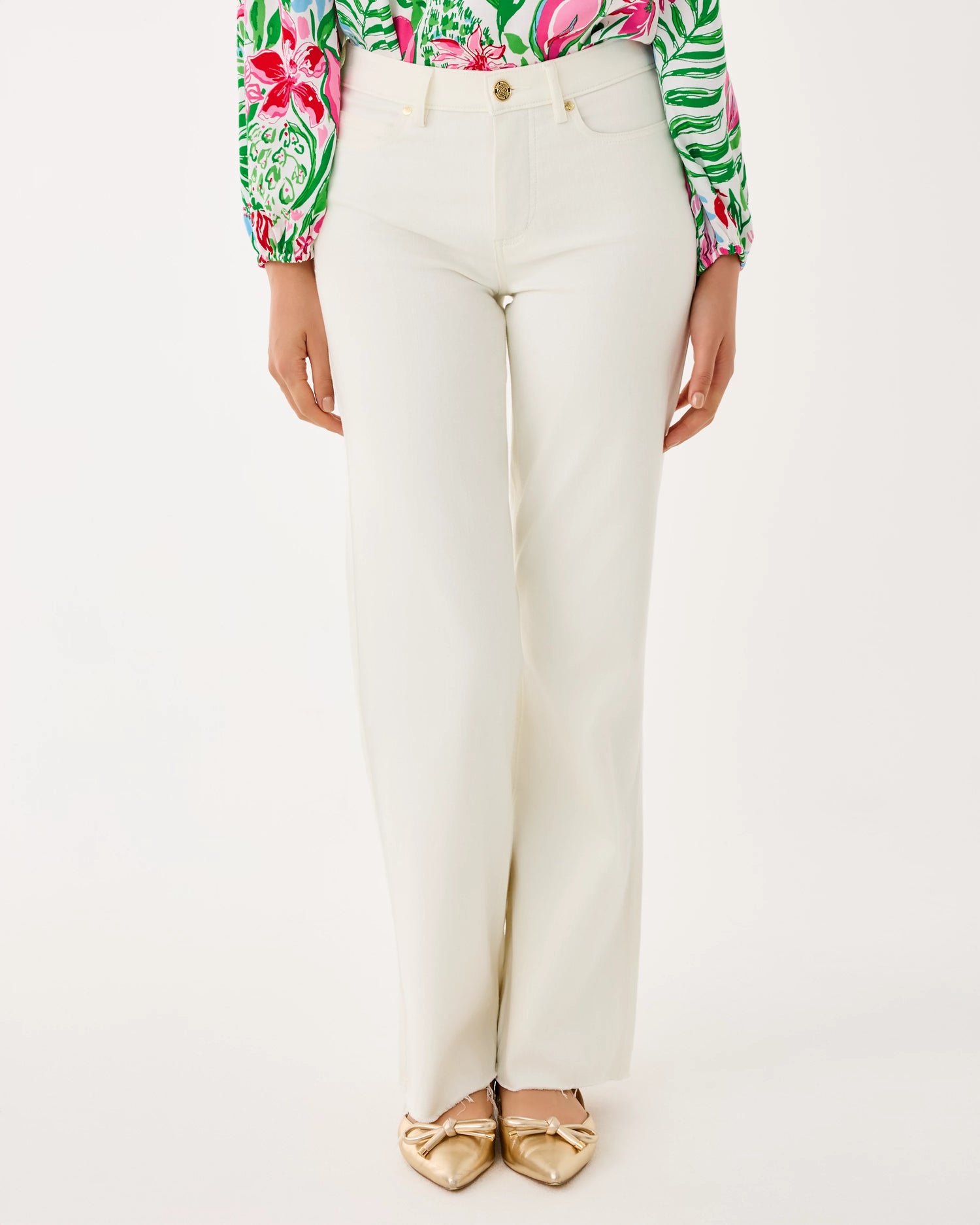 Person wearing white pants with a colorful top on a white background