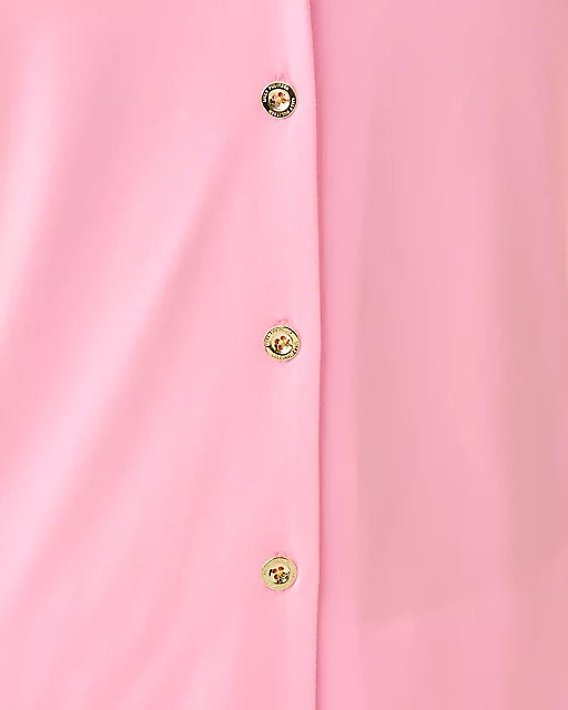 Close-up of a pink garment with gold buttons