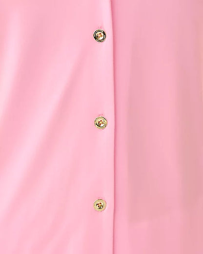 Close-up of a pink garment with gold buttons