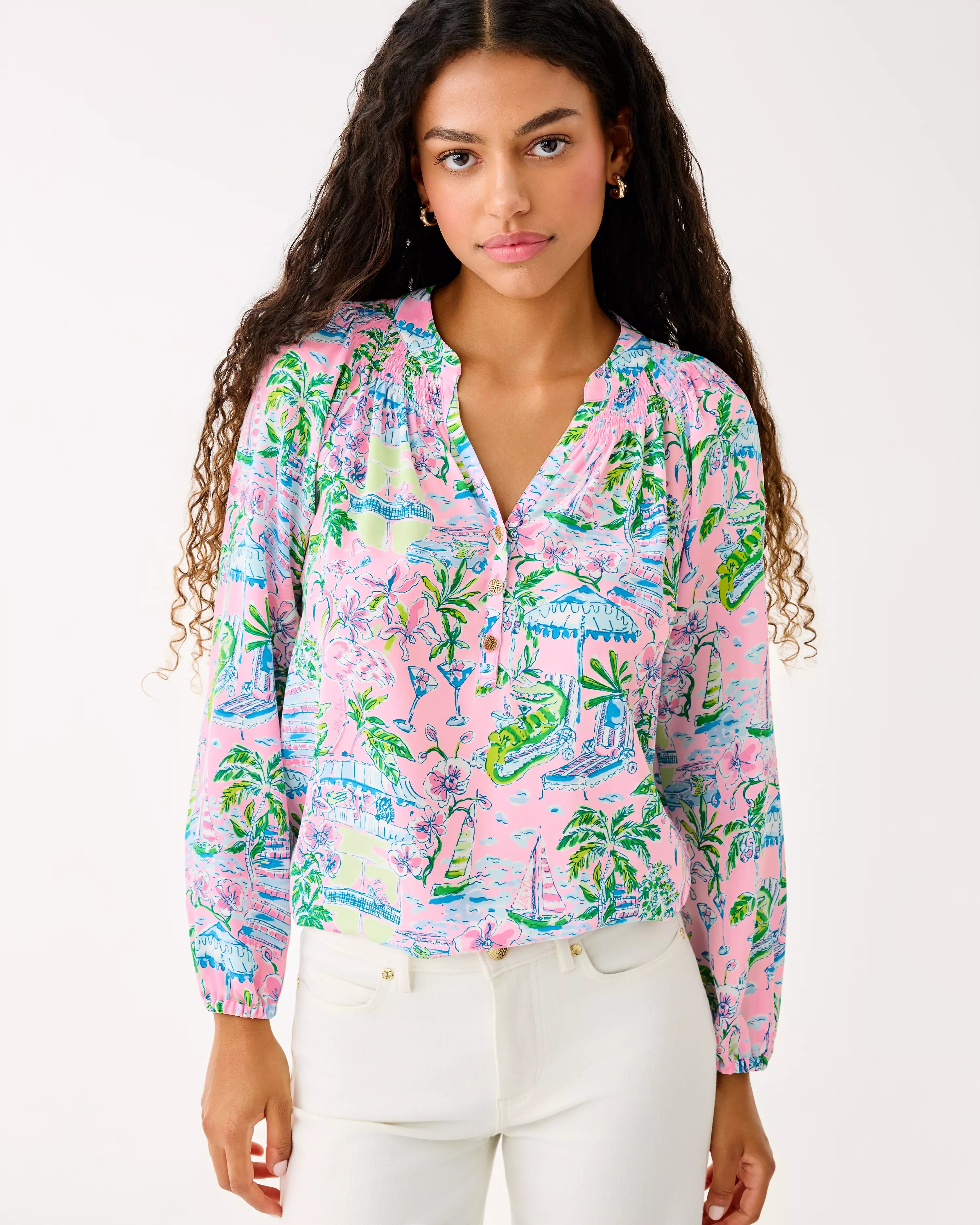 Woman wearing a colorful patterned blouse with a white background