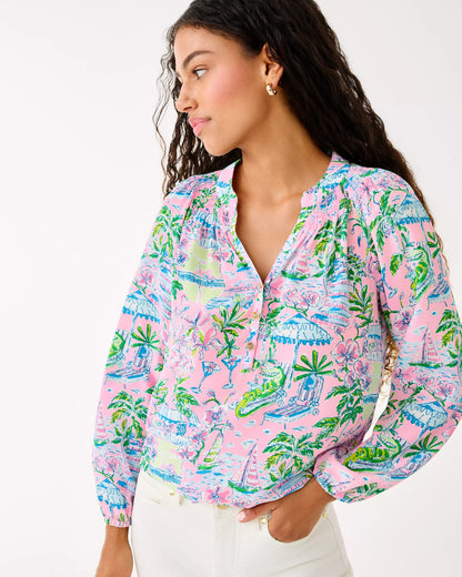 Woman wearing a colorful patterned blouse with a white background