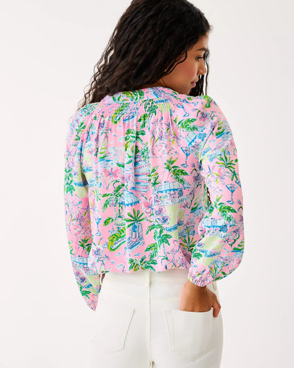 Woman wearing a colorful patterned blouse with a white background