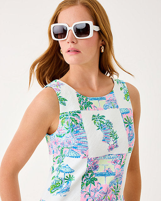 Woman wearing a colorful sleeveless dress with a white background