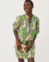 A woman modeling a short-sleeved mini dress with a vibrant green, yellow, and blue floral print lilly pulitzer mialeigh dress Color: Multi Lil Palm Prowl Engineered Woven Dress