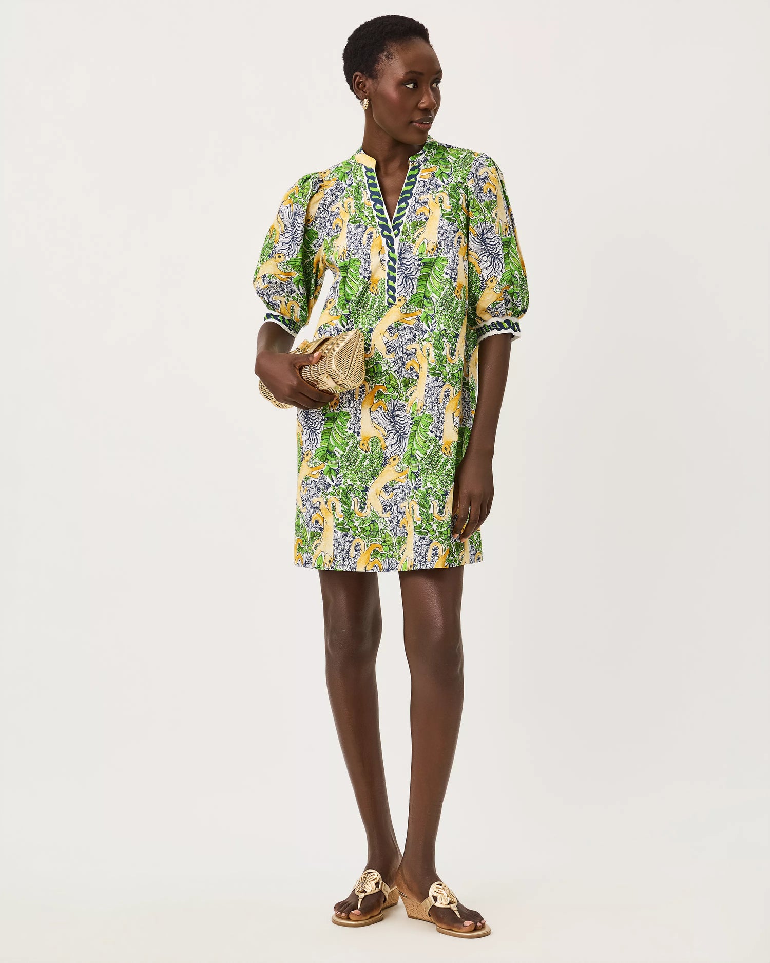 A woman modeling a short-sleeved mini dress with a vibrant green, yellow, and blue floral print lilly pulitzer mialeigh dress Color: Multi Lil Palm Prowl Engineered Woven Dress